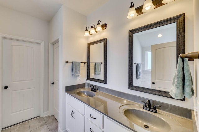 bathroom with a sink, double vanity, and tile patterned flooring