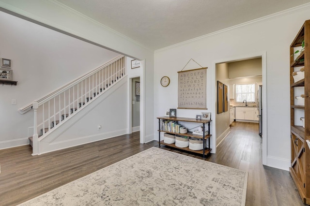 interior space with stairs, baseboards, ornamental molding, and dark wood-style flooring