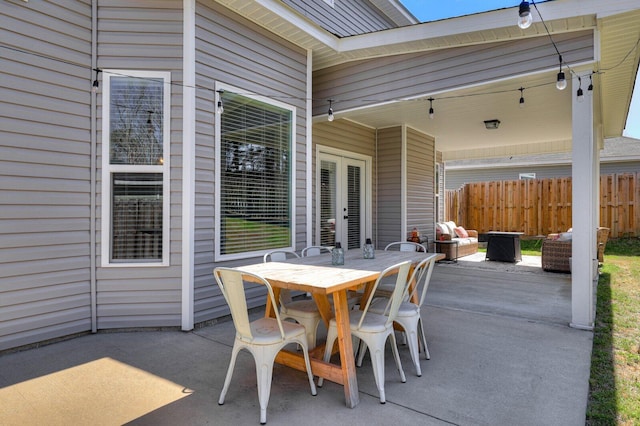 view of patio / terrace with outdoor dining space, french doors, and fence