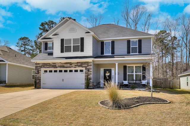 view of front of property with a front lawn, stone siding, a porch, concrete driveway, and an attached garage