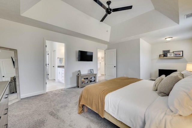 bedroom with a raised ceiling, baseboards, and light carpet