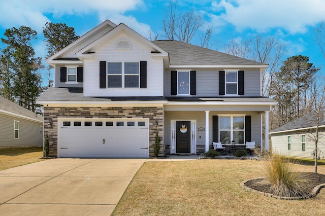 view of front facade with driveway, a front lawn, stone siding, a porch, and an attached garage