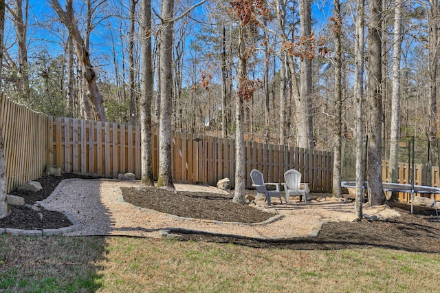 view of yard featuring a trampoline and a fenced backyard