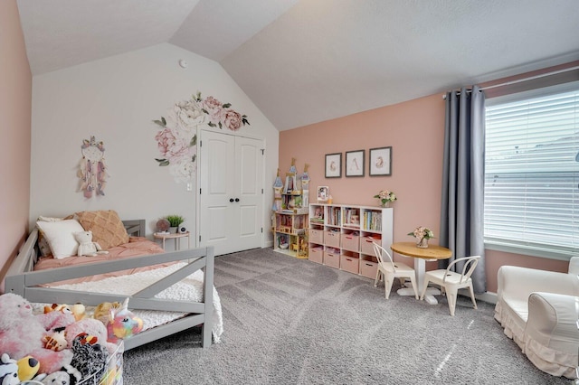 carpeted bedroom with a closet and vaulted ceiling