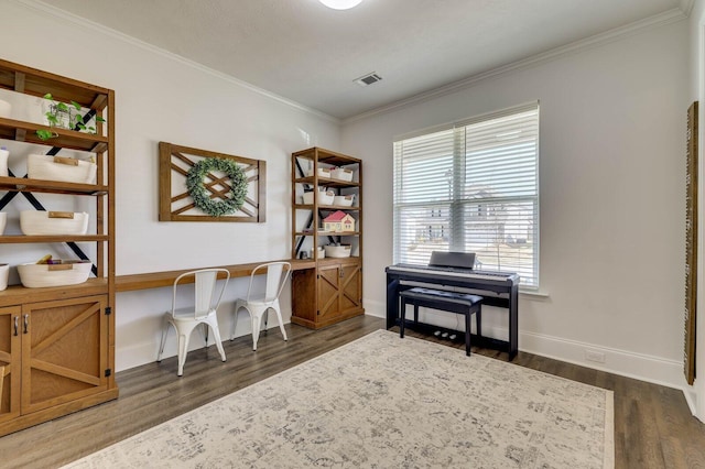 home office featuring dark wood-type flooring, baseboards, visible vents, and ornamental molding