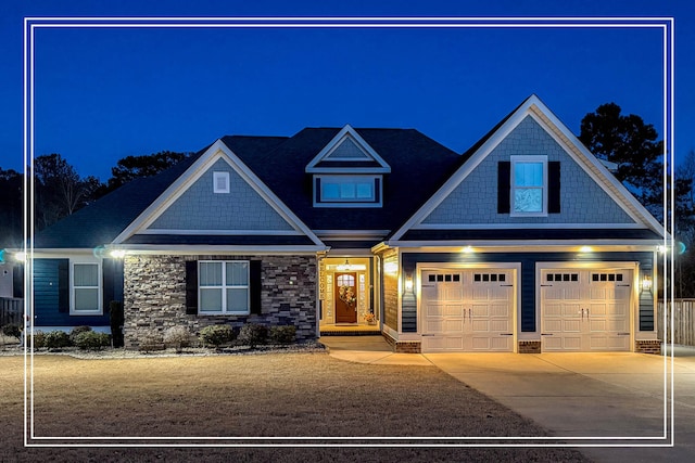 craftsman inspired home with a garage, concrete driveway, and stone siding