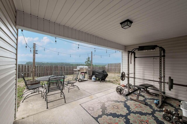 view of patio with outdoor dining area, a fenced backyard, and grilling area