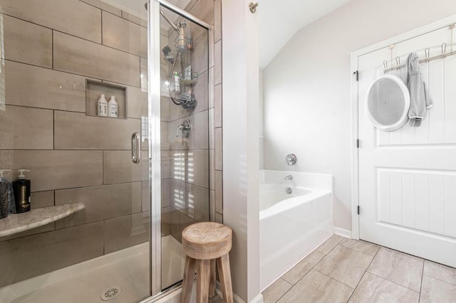 full bathroom with a bath, lofted ceiling, and a stall shower