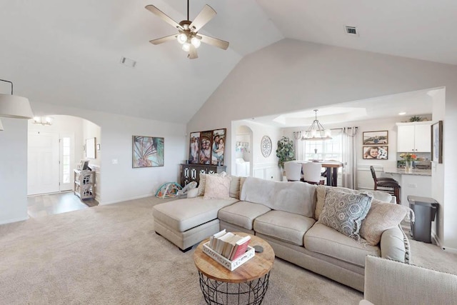 living room with arched walkways, visible vents, light carpet, and ceiling fan with notable chandelier