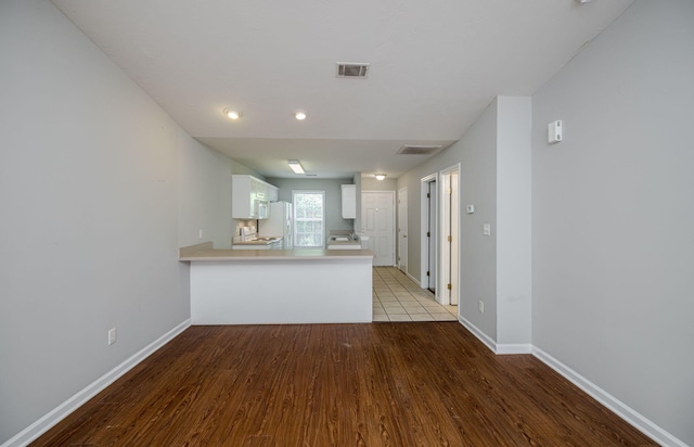 5034 Wheeler Lake Rd, Augusta, GA 30909 - kitchen with light wood-style floors, white cabinetry, a peninsula, and baseboards