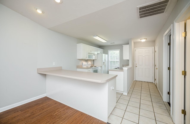 5034 Wheeler Lake Rd, Augusta, GA 30909 - kitchen with white appliances, a peninsula, white cabinetry, light countertops, and baseboards