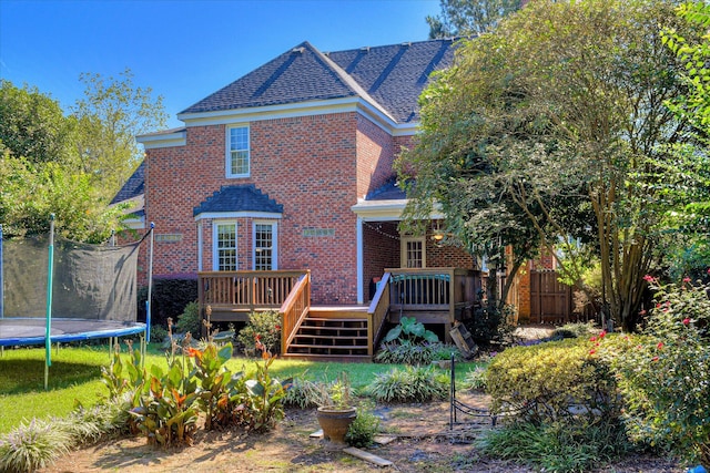 3463 Rhodes Hill Dr, Augusta, GA 30907 - back of property with a trampoline, brick siding, a deck, roof with shingles, and stairs
