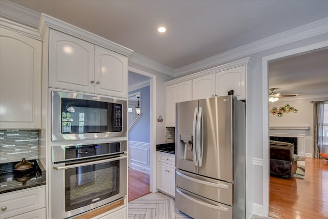 3463 Rhodes Hill Dr, Augusta, GA 30907 - kitchen with stainless steel appliances, white cabinets, ornamental molding, dark stone countertops, and backsplash