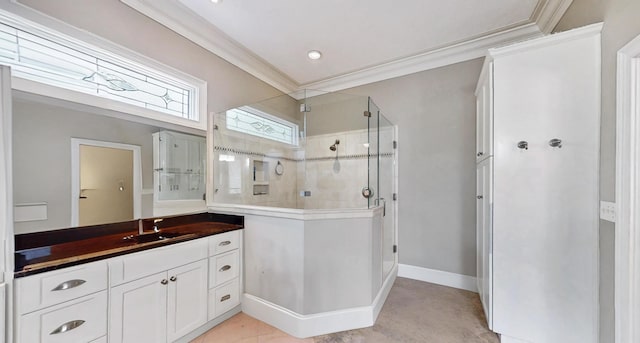 bathroom featuring vanity, ornamental molding, and a shower with shower door