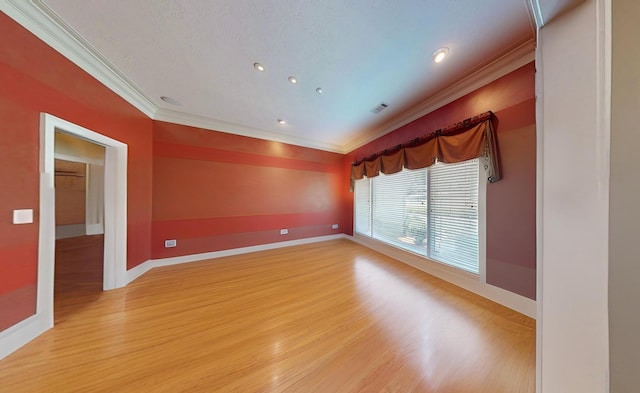 empty room featuring crown molding and wood-type flooring