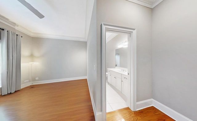 hallway featuring crown molding, sink, and light hardwood / wood-style floors