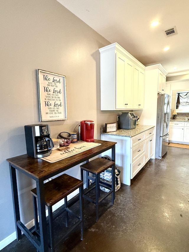 kitchen featuring white cabinets and stainless steel fridge