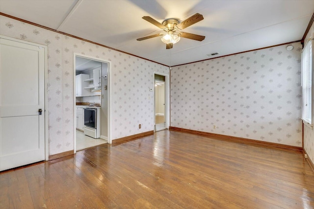 interior space with ceiling fan, light hardwood / wood-style flooring, ensuite bathroom, a walk in closet, and ornamental molding
