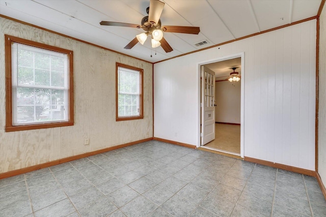 empty room with ceiling fan and crown molding