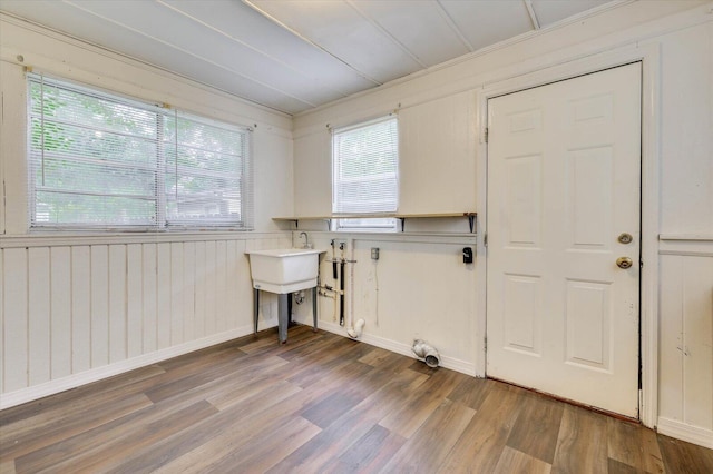 laundry room with hardwood / wood-style flooring and ornamental molding