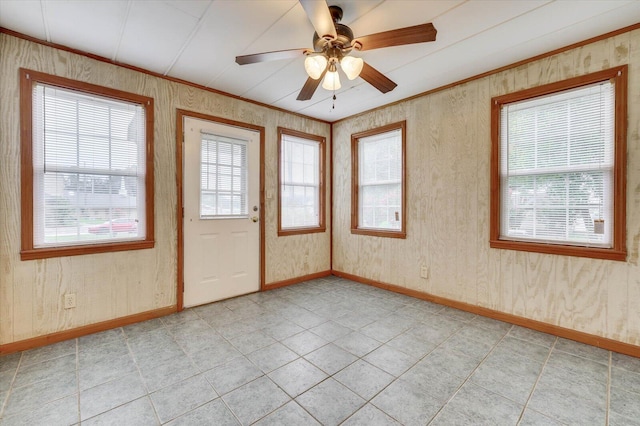 tiled spare room featuring ceiling fan and ornamental molding