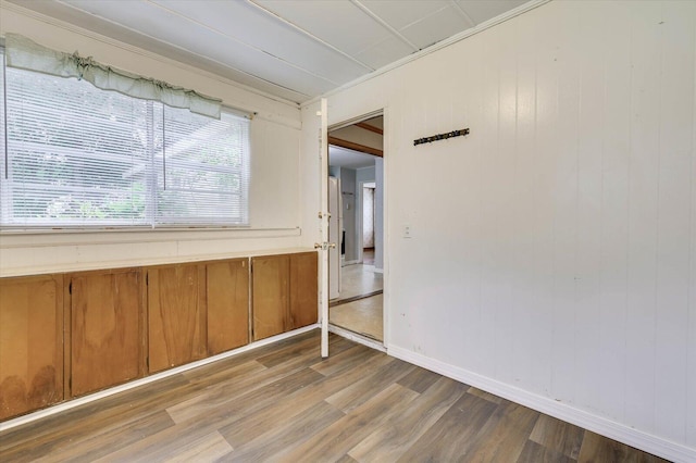 spare room with crown molding and light wood-type flooring