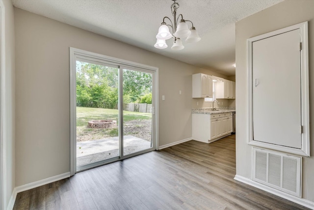 2913 Kings View Dr, Augusta, GA 30909 - unfurnished dining area featuring a chandelier, wood finished floors, and a textured ceiling