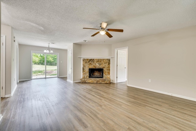 2913 Kings View Dr, Augusta, GA 30909 - unfurnished living room with a ceiling fan, a textured ceiling, a chandelier, wood finished floors, and a stone fireplace