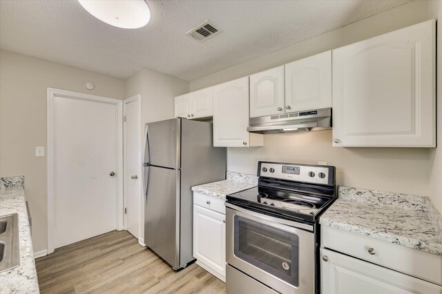 2913 Kings View Dr, Augusta, GA 30909 - kitchen with under cabinet range hood, stainless steel appliances, light wood-style flooring, white cabinets, and a textured ceiling