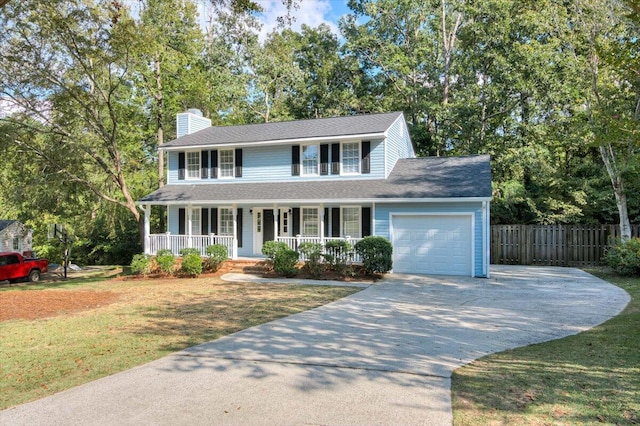 colonial house with a porch, a garage, and a front lawn