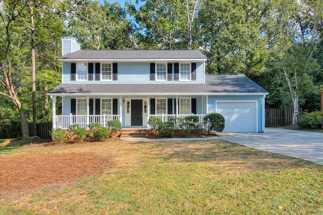 view of front of house featuring a front yard, a garage, and covered porch