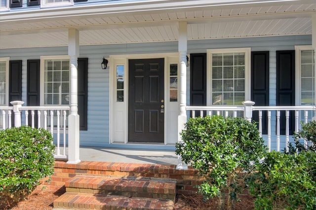 view of exterior entry featuring covered porch