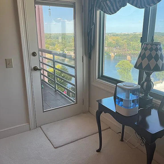 doorway with carpet, a water view, and a wealth of natural light