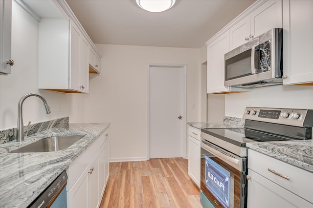 355 E Park Way Ct, Martinez, GA 30907 - kitchen featuring appliances with stainless steel finishes, a sink, light wood-style flooring, white cabinets, and light stone countertops