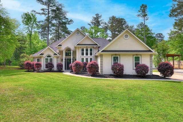view of front facade with stucco siding, a front lawn, and a shingled roof