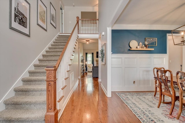 4002 Backwater Ct, Evans, GA 30809 - foyer featuring crown molding, a decorative wall, light wood-style flooring, a wainscoted wall, and stairs