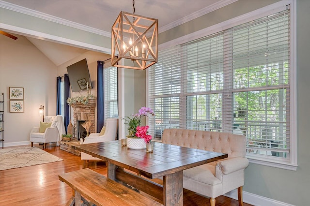 4002 Backwater Ct, Evans, GA 30809 - dining room featuring baseboards, an inviting chandelier, a fireplace, crown molding, and wood finished floors