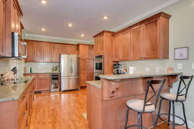 4002 Backwater Ct, Evans, GA 30809 - kitchen featuring a peninsula, light wood-style floors, beverage cooler, and appliances with stainless steel finishes