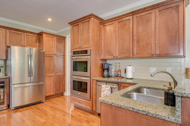 4002 Backwater Ct, Evans, GA 30809 - kitchen featuring light wood-style floors, ornamental molding, appliances with stainless steel finishes, light stone counters, and a sink