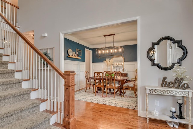 4002 Backwater Ct, Evans, GA 30809 - dining space featuring crown molding, a decorative wall, a wainscoted wall, wood finished floors, and stairs