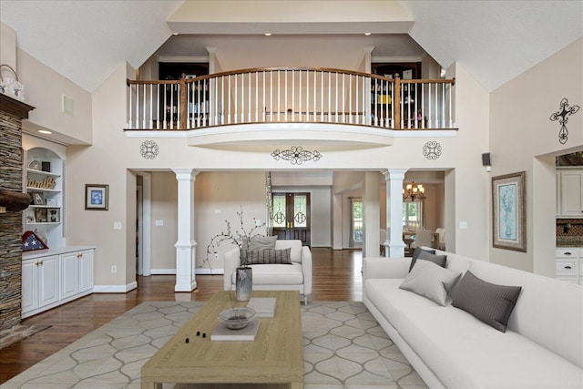 698 Heggies Ridge Dr, Appling, GA 30802 - living area with decorative columns, light wood-style floors, high vaulted ceiling, and baseboards