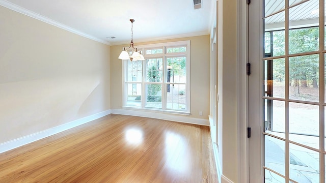 unfurnished room with crown molding, a chandelier, and light hardwood / wood-style floors