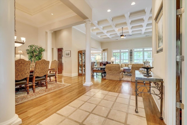 interior space with coffered ceiling, wood-type flooring, ceiling fan with notable chandelier, beamed ceiling, and ornate columns