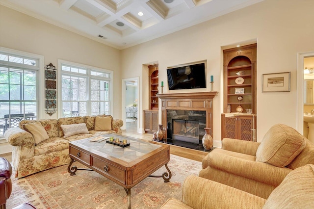 living room featuring built in features, beamed ceiling, a high ceiling, coffered ceiling, and light hardwood / wood-style floors