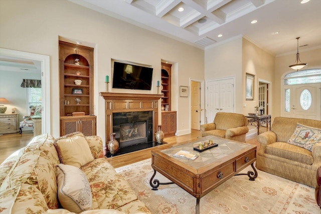 living room with beamed ceiling, a high ceiling, coffered ceiling, and light wood-type flooring