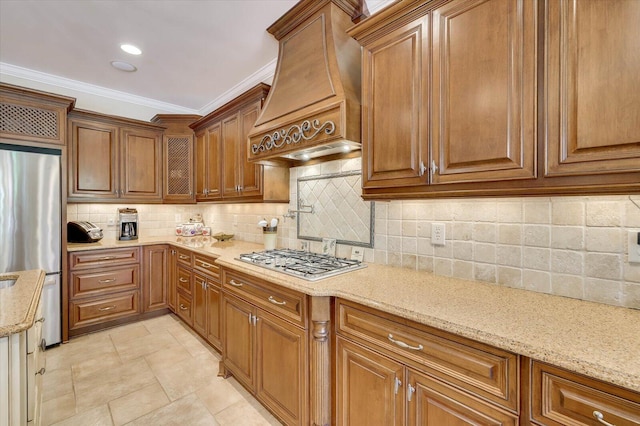 kitchen featuring light stone countertops, appliances with stainless steel finishes, custom range hood, and crown molding