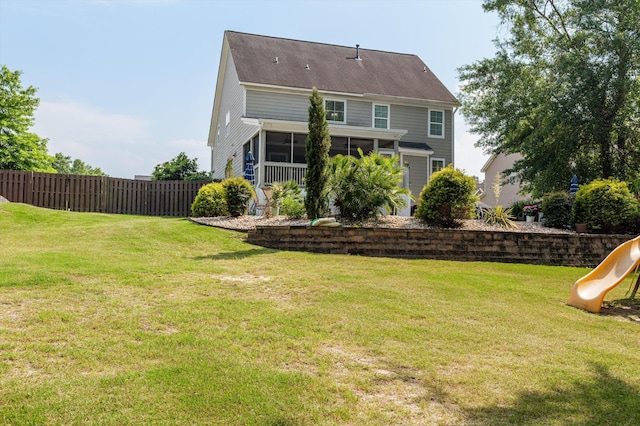rear view of house with a playground and a sunroom