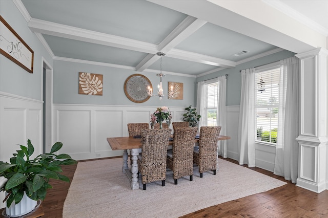 dining room with a decorative wall, a chandelier, beam ceiling, wainscoting, and wood finished floors