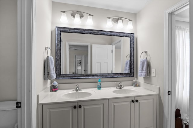bathroom featuring double vanity and toilet