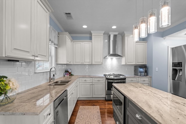 kitchen with stainless steel appliances, wall chimney exhaust hood, a sink, crown molding, and dark wood-type flooring